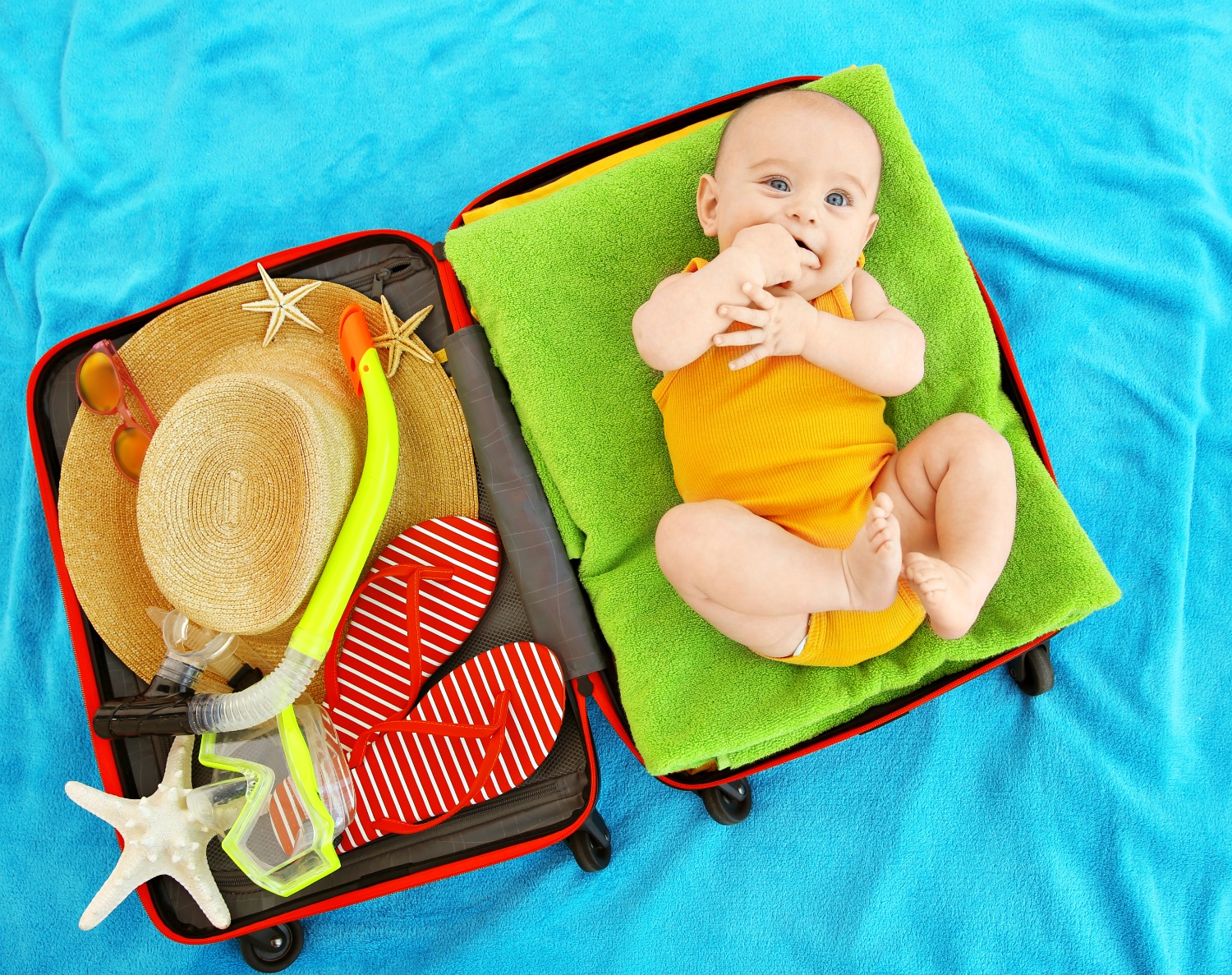 Baby curled up in a suitcase with the other half full of holiday essentials - as I planned our first trip away, I tried to find out if you should travel before baby vaccinations